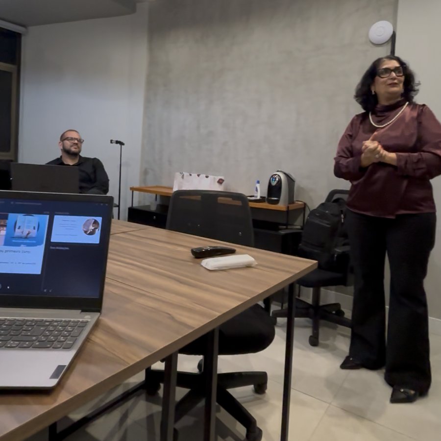 Participante em pé apresentando para a turma em sala de treinamento.