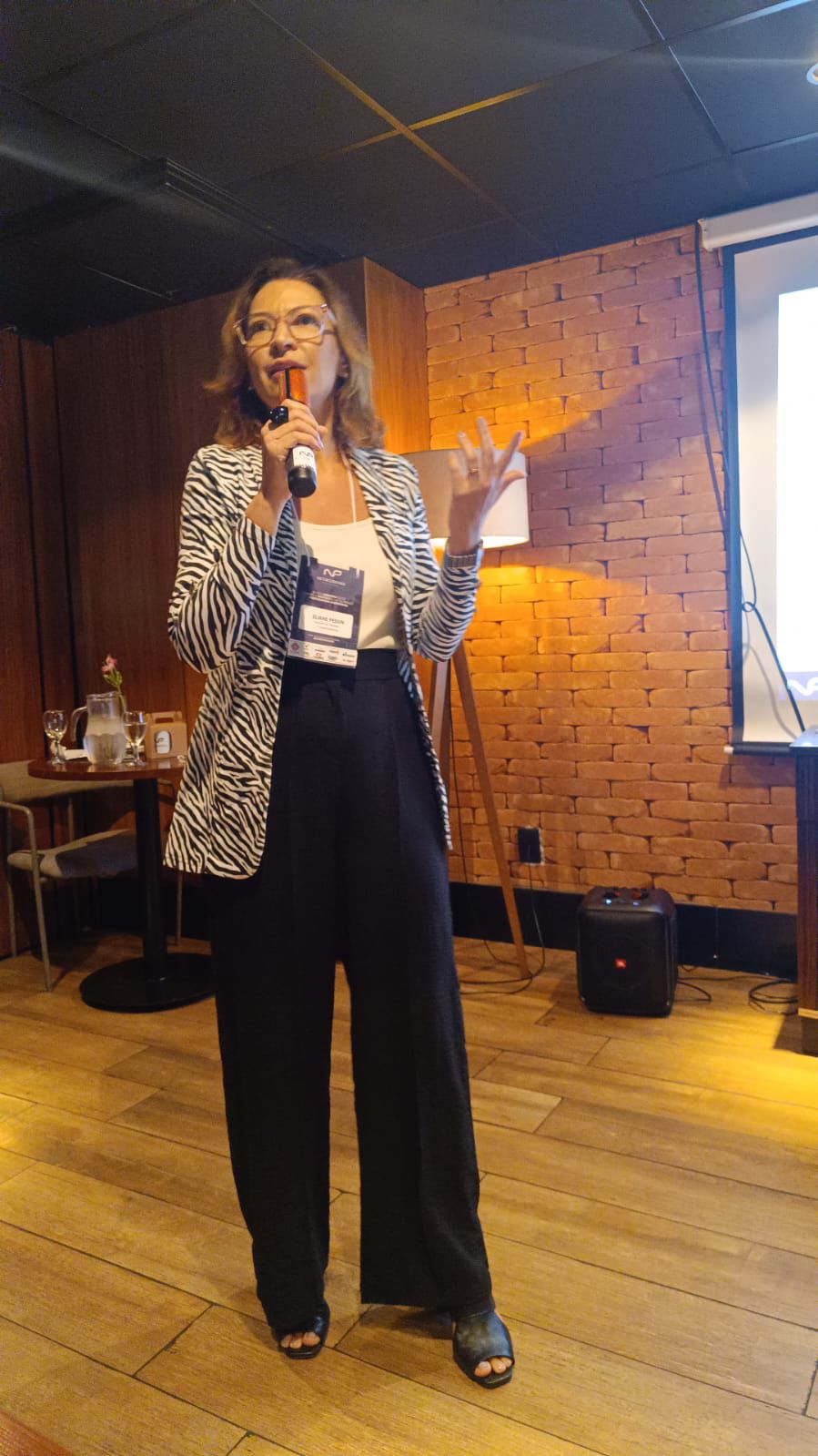 Eliane Pessin discursando ao microfone durante um evento.